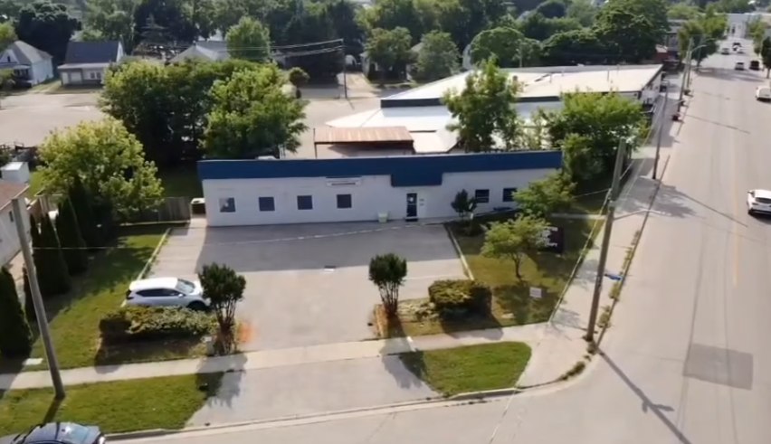 Aerial view of the Shuqair Health & Wellness clinic exterior and parking lot at 195 Harkness Street in Sarnia.